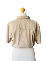 Beige jacket on a mannequin against a neutral wall.