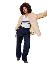 Woman in a beige coat and navy pants.