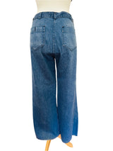 Blue jeans on a mannequin against a white door background