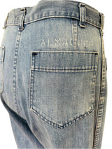 Close-up of a pair of blue jeans with 'Almaguer" on the back pocket.