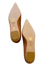 A pair of pointed-toe flats shown from the sole. The shoes feature a light beige leather upper, a medium brown heel counter, and a tan protective rubber pad on the heel.